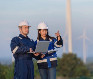 two-engineers-working-holding-report-wind-turbine-farm-power-generator-station-mountainthailand-peopletechnician-man-woman-discuss